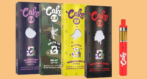 four colorful vape product boxes with a red vape pen displaying Cake 2 logo and various cannabis strains including blueberry cookies and wedding cake 2 cannabis